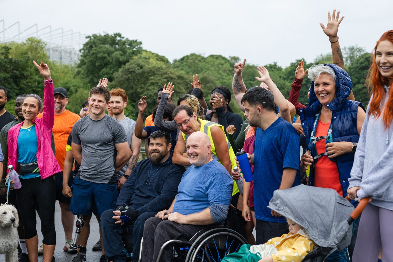 Group of run participants taking part in a fun run in Leazes Park in Newcastle upon Tyne in the North East of England. They are ready to run in the rain along the lakeside. The race is open to people of all ages and abilities and is also dog friendly.